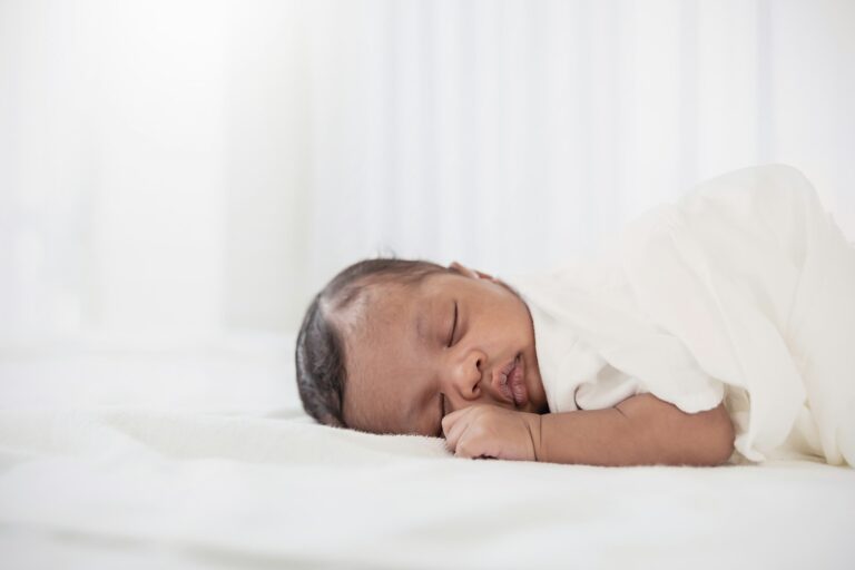 Portrait of close up black African American baby face sleep tight peaceful